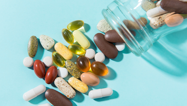 Eye vitamins and supplement capsules spilling out of bottle