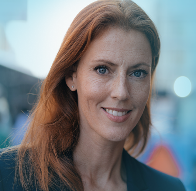 Woman with red hair and blue eyes smiling looking at camera
