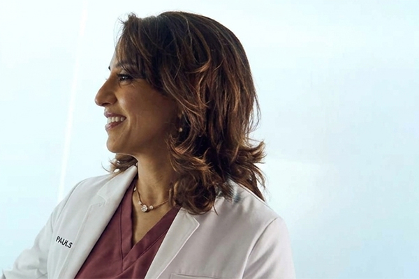 A Doctor in white lab coat standing beside advanced eye care equipment, preparing for a refractive wavelight surgery procedure.