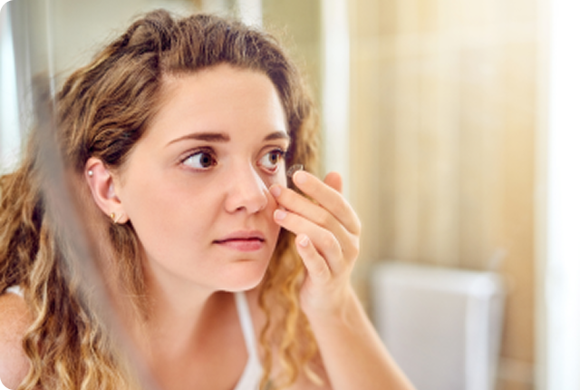 Photo of a woman putting on a contact lens