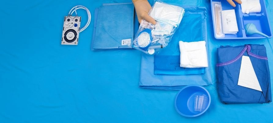 An operating room table with various alcon products laid out and ready to begin an operation.