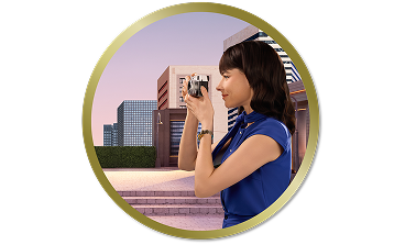 Woman outdoors taking a photo with a camera in front of modern city buildings