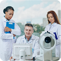 Three eye care professionals review the results of diagnostic equipment in a clinical setting.