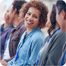 A group of people at a professional event, with a woman smiling at the camera.