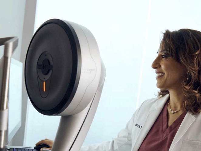 A Doctor in white lab coat standing beside advanced eye care equipment, preparing for a refractive wavelight surgery procedure.