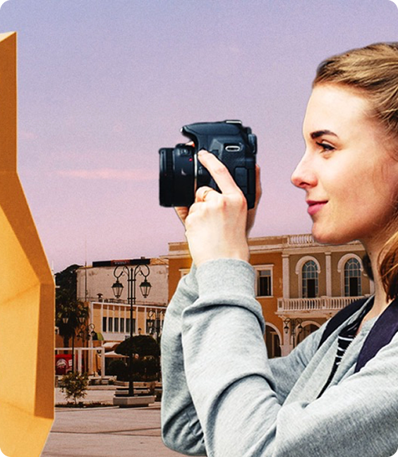Woman photographing city architecture at sunset
