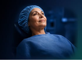 Patient wearing a surgical cap and gown before an ophthalmic procedure