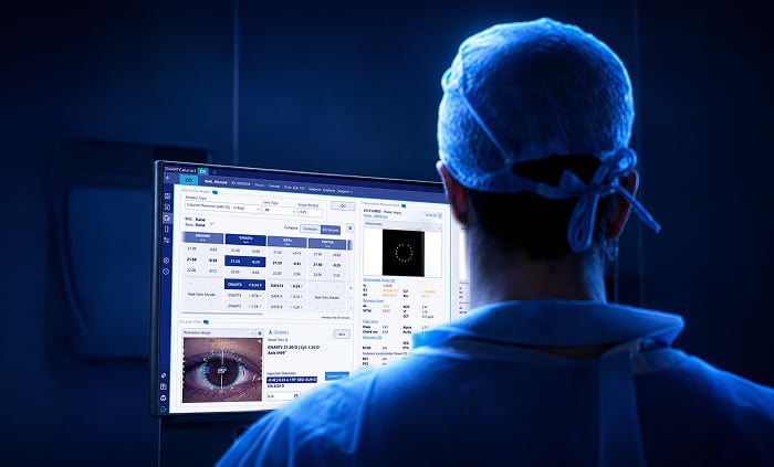 Ophthalmic surgeon reviewing patient data and surgical planning information on a monitor