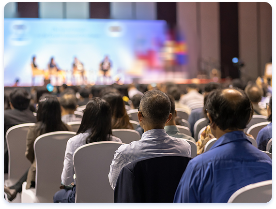 Attendees seated in an audience during a professional conference session