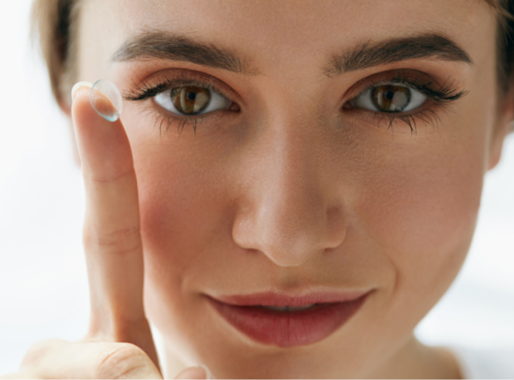 Woman applying contact lenses