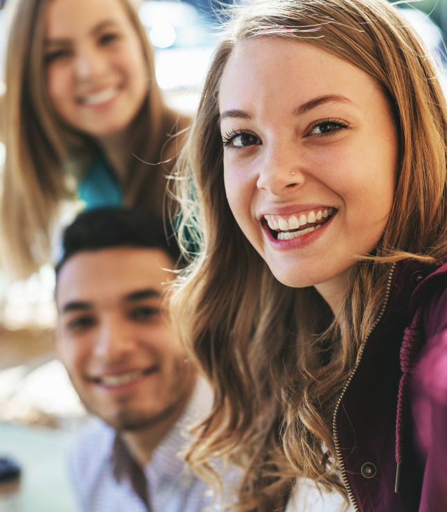 in the foreground a smiling woman in the background a man and a woman