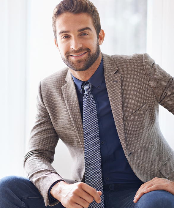 A smiling man in a jacket and tie