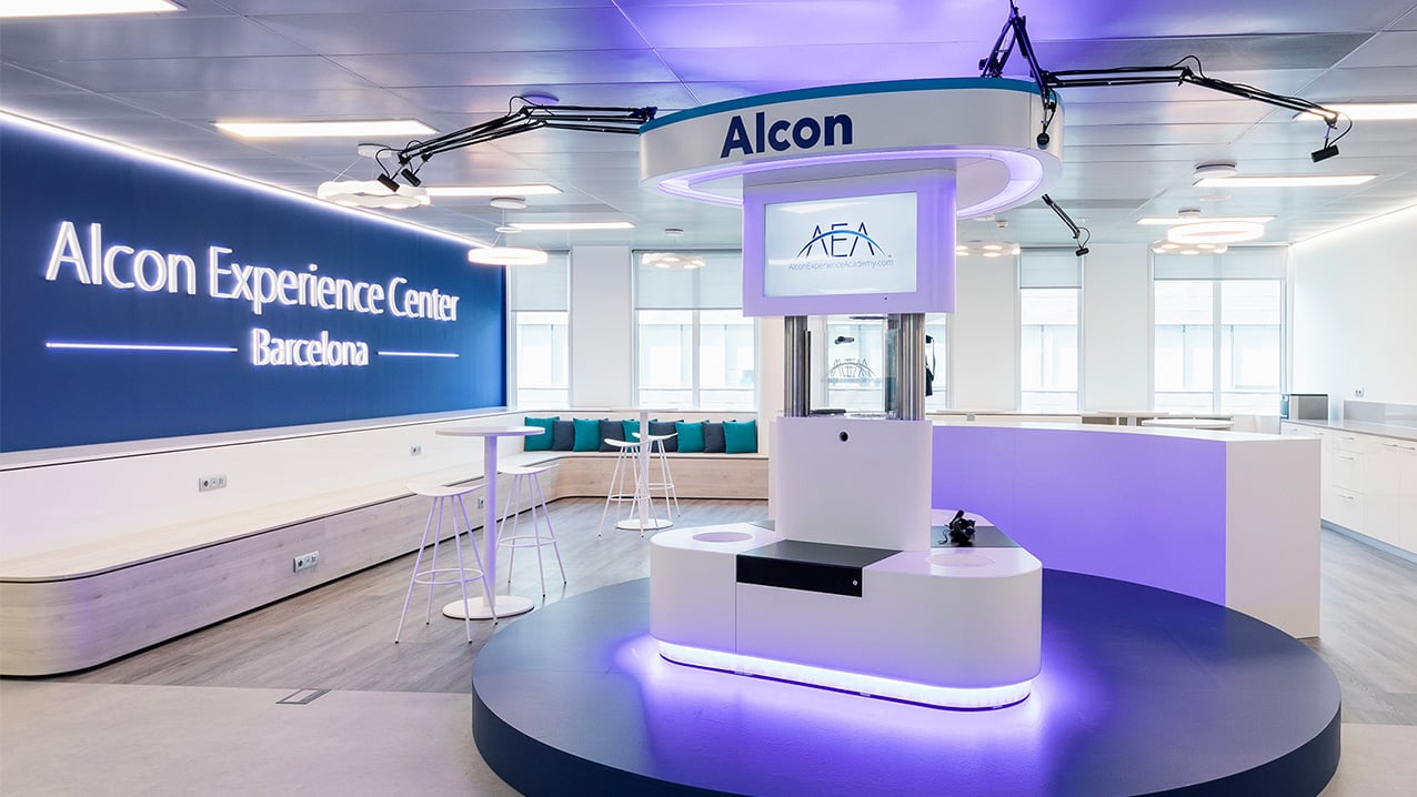 Alcon Experience Center in Barcelona featuring a modern training space with interactive displays and seating area.
