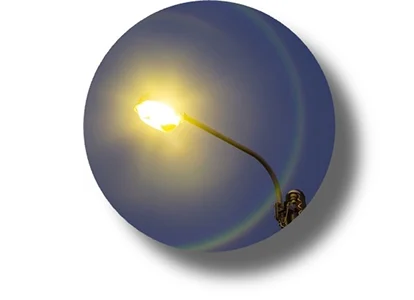 Streetlight at night with visible halo effect, illustrating glare and light scatter around light sources