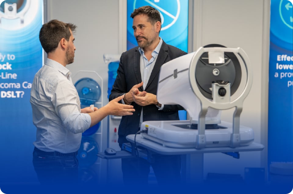 Demonstration of an ophthalmic diagnostic device during a discussion at a medical exhibition.