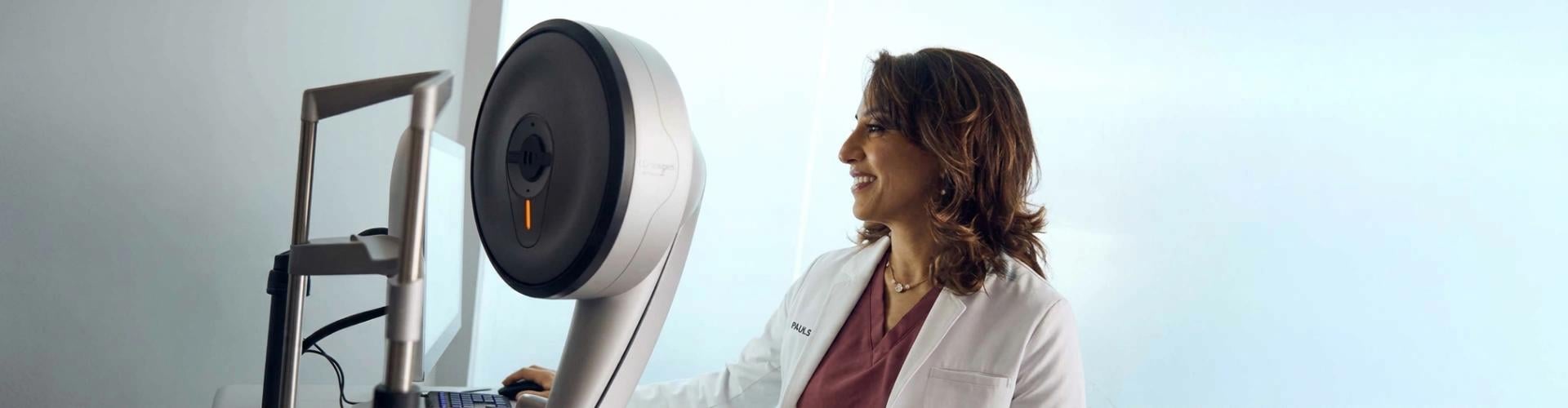 A Doctor in white lab coat standing beside advanced eye care equipment, preparing for a refractive wavelight surgery procedure.