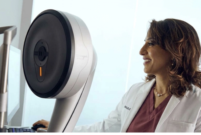 A Doctor in white lab coat standing beside advanced eye care equipment, preparing for a refractive wavelight surgery procedure.