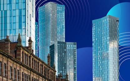 Modern glass skyscrapers rising above historic buildings in Manchester’s commercial district.